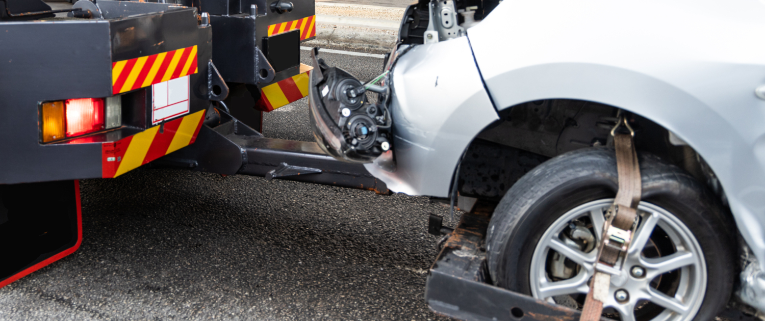 Tow truck towing broken down car from accident